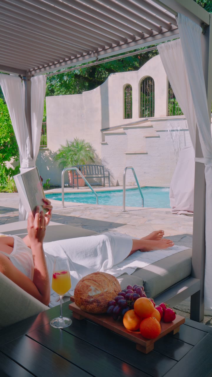 A guest reading beneath a cabana beside the Kenwood pool
